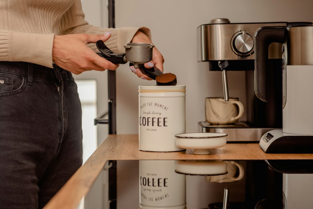 a person pouring a cup of coffee from a coffee maker